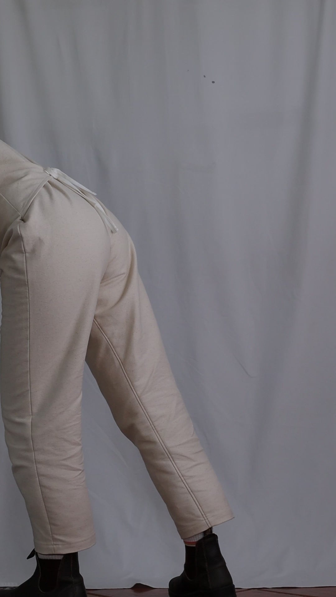 Video of woman showing the yoke overalls / dungarees fit and denim fabric.